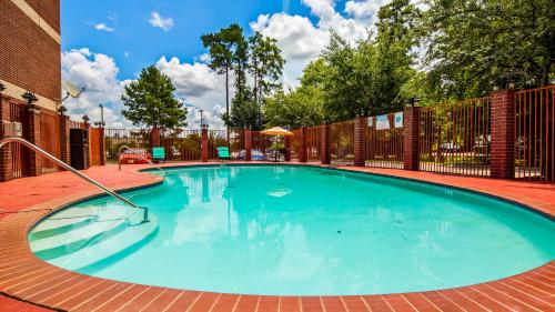 a large blue swimming pool with a fence at Best Western Plus The Woodlands in The Woodlands