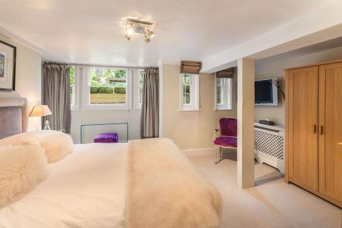 a bedroom with a large white bed and a television at The Garden Flat in London