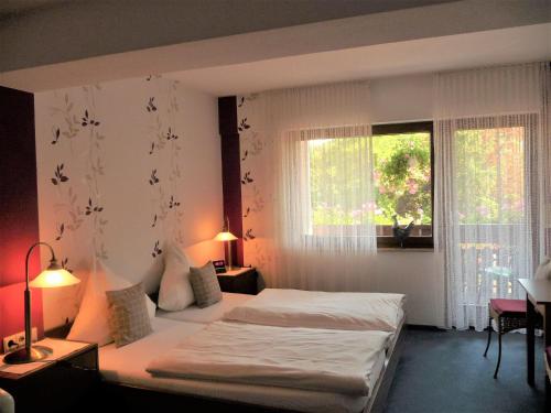 ein Hotelzimmer mit einem Bett und einem Fenster in der Unterkunft Hotel "Woiler Hof" garni in Eslohe