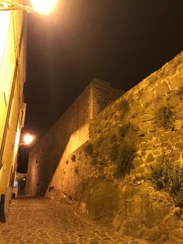 a stone wall at night with a street light at Il doppio nodo in Castelsardo