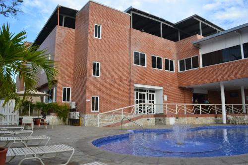 a building with a swimming pool in front of a building at Hotel Villa Playa Grande in Playa Grande