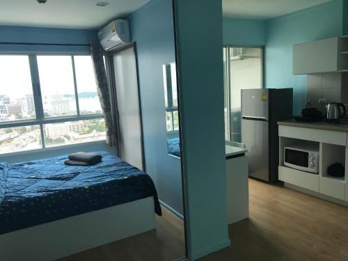 a small room with a bed and a mirror at Lumpini Ville Wong Amat Beach in North Pattaya
