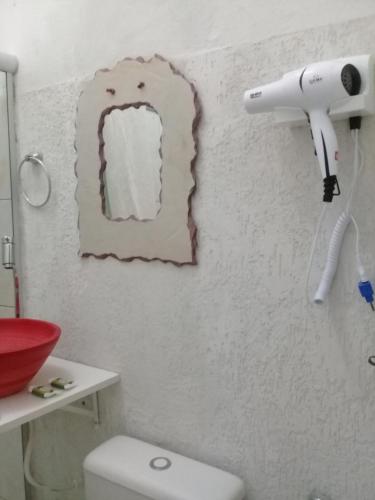 baño con aseo y secador de pelo en la pared en Pousada Villas Colossos, en Lençóis