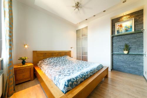 a bedroom with a bed with a blue comforter at Brivibas LUX in Riga