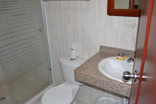 a bathroom with a toilet and a sink and a shower at Hotel Villa Playa Grande in Playa Grande