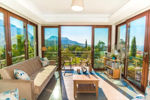 a living room with a couch and large windows at Bellapais Apartments in Kyrenia