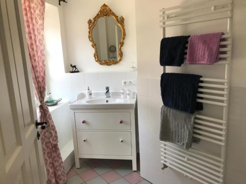a bathroom with a sink and a mirror and towels at Ferienwohnungen im Lüftlmalereck, Mussldomahaus in Oberammergau