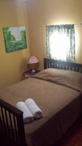 a bedroom with a bed with two towels on it at Hospedaje Rampolla's in Volcán