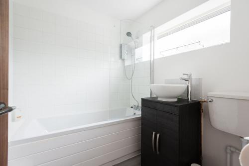 The Century Chalet - Contemporary 2BDR Townhouse with Parking في أوكسفورد: حمام مع حوض وحوض استحمام