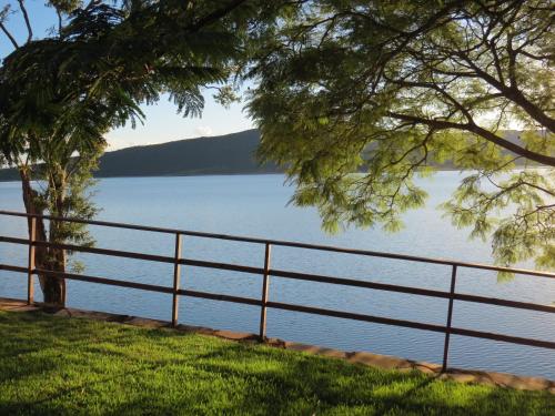 a fence next to a body of water at Pousada Mar de Minas in Capitólio