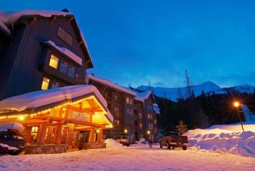 a lodge in the snow at night at Snow Creek Lodge by Fernie Lodging Co in Fernie