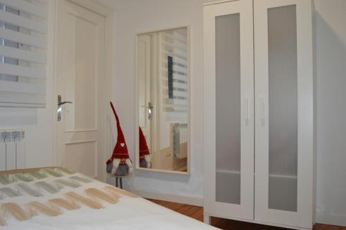 a white bedroom with a bed and a mirror at Apartamento La Paz in Logroño