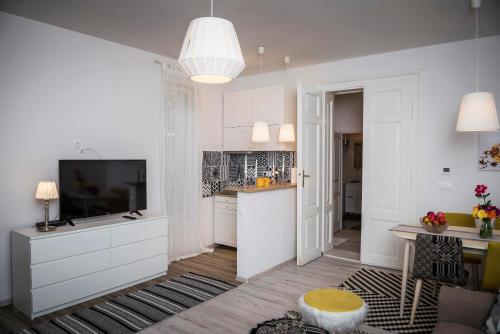 ein Wohnzimmer mit einem TV und einer Küche in der Unterkunft Reghin Guest House in Reghin