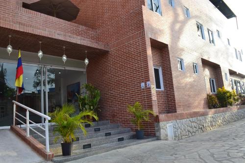 a brick building with a flag and some plants at Hotel Villa Playa Grande in Playa Grande