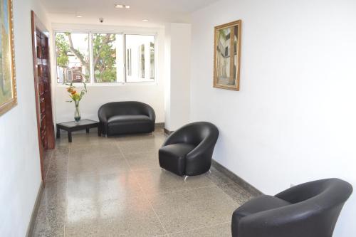 a waiting room with black chairs and a window at Hotel Villa Playa Grande in Playa Grande