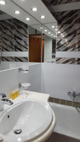 リヴィウにあるSoprano Apartment Tamanskaのバスルーム(白い洗面台、鏡付)