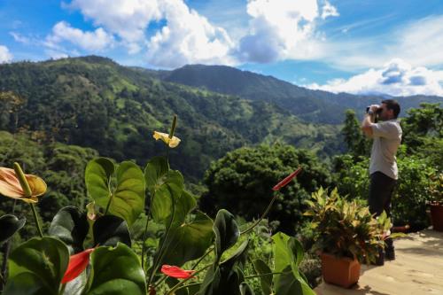 a man taking a picture of the mountains at Santa Juana Lodge & Nature Reserve in Quepos