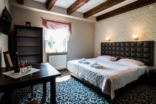 a bedroom with a large bed and a table at Pod Ksiecia Gorka in Oleszyce