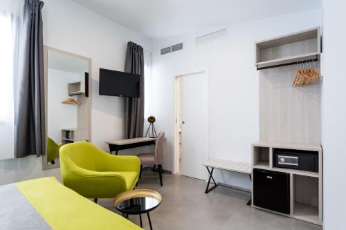 a hotel room with a bed and a yellow chair at La Puerta de Palacio - Adults Only in Seville