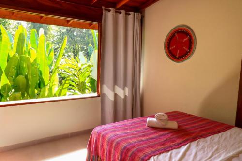 a bedroom with a bed and a large window at Moksha Surf Yoga in Ubatuba