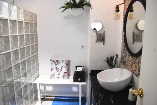 a bathroom with a white sink and a mirror at El Patio del Limonero in Écija
