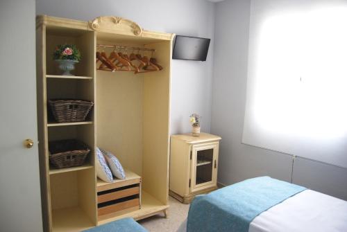 a bedroom with a bed and a closet with shoes at El Patio del Limonero in Écija