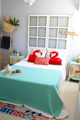 a bedroom with a bed with red pillows on it at El Patio del Limonero in Écija