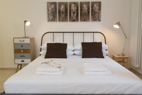 una camera con un letto bianco con due cuscini di Tocco Barocco - Locazioni Brevi - a Ragusa