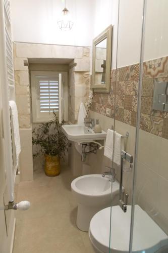 a bathroom with a toilet and a sink at Tocco Barocco - Locazioni Brevi - in Ragusa