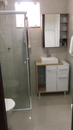 a bathroom with a shower and a sink and a toilet at Apartamento centro Porto belo!! in Porto Belo
