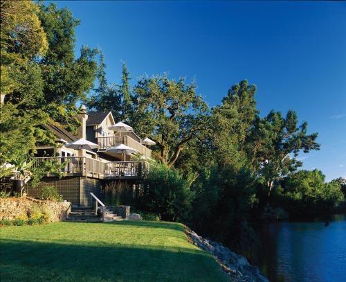 a large house on the side of a river at Milliken Creek Inn in Napa