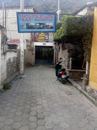 a scooter parked in front of a building with a sign at Hospedaje Eli Panajachel in Panajachel