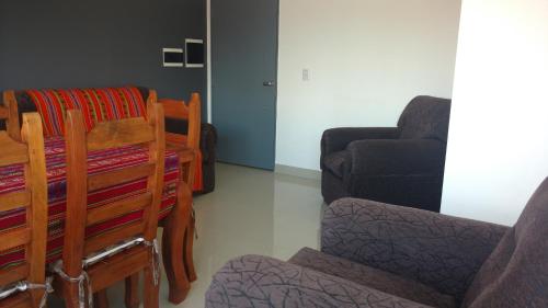 sala de estar con silla y sofá en Alvarado Departamentos en Salta