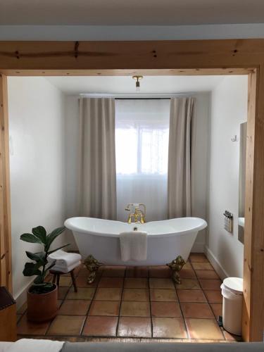 a white bath tub in a bathroom with a window at Alamo Motel in Los Alamos