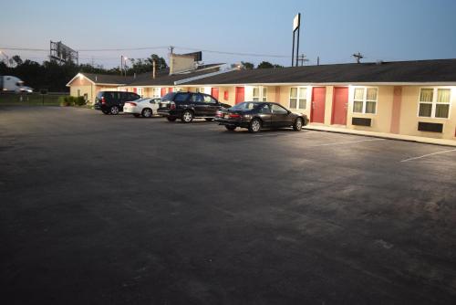 a parking lot with cars parked in front of a building at White Oaks Motel Pennsville/Carneys Point in Pennsville