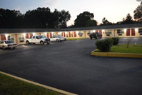 un edificio con coches estacionados en un estacionamiento en White Oaks Motel Pennsville/Carneys Point, en Pennsville