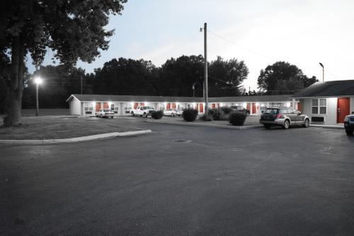 a building with cars parked in a parking lot at White Oaks Motel Pennsville/Carneys Point in Pennsville