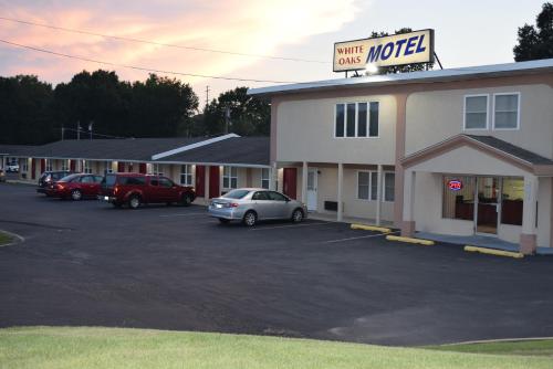 un pequeño motel con coches aparcados en un estacionamiento en White Oaks Motel Pennsville/Carneys Point, en Pennsville