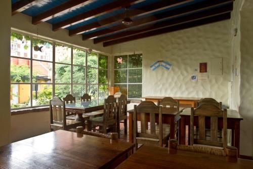 a dining room with a table and chairs and windows at Alamo Hostel & Suites in Mendoza