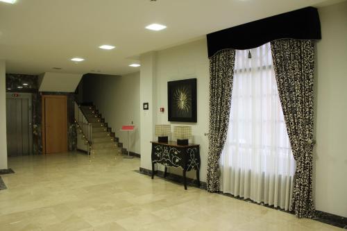 un couloir avec un escalier, une fenêtre et un escalier dans l'établissement Hospedium Hotel Vittoria Colonna, à Medina de Ríoseco