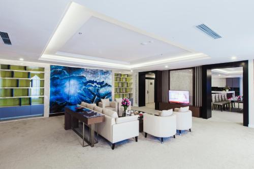 a living room with white furniture and a blue painting at Muong Thanh Luxury Ha Nam in Phủ Lý