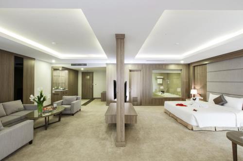 a bedroom with a bed and a living room at Muong Thanh Luxury Ha Nam in Phủ Lý