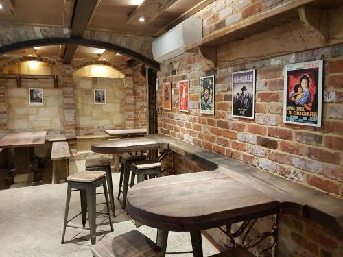 a bar with tables and stools in a brick wall at Bridgefield Guest House in Margaret River Town