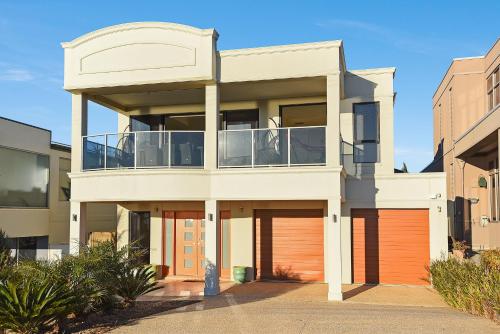 a large white house with orange garage doors at Ocean View Moana - C21 SouthCoast Holidays in Moana