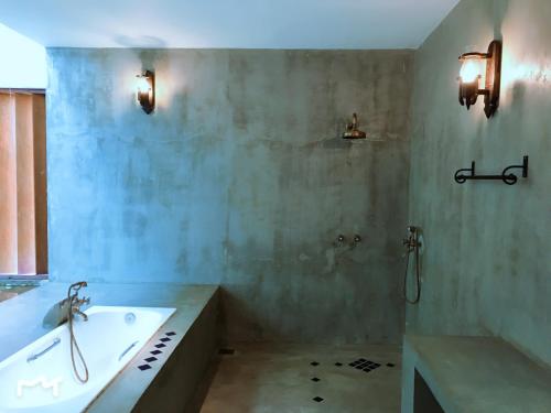 a bathroom with a tub and a sink and a bath tub at Coza Ceylon in Mount Lavinia