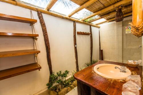 a bathroom with a sink and a mirror at Balihai Bungalows in Canoas De Punta Sal