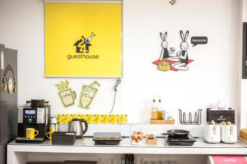 a kitchen with a counter with a yellow sign on the wall at 24 Guesthouse Jeonju in Jeonju