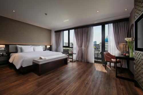 a bedroom with a large bed and large windows at Grandiose Hotel & Spa in Hanoi