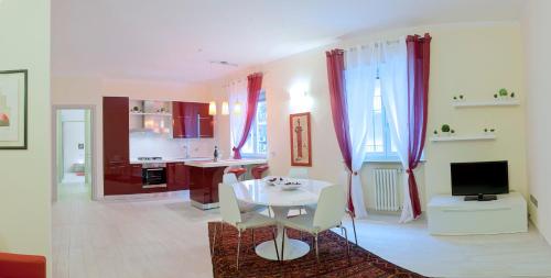 Apartment Home Marconi25 في فيرونا: غرفة معيشة مع طاولة بيضاء ومطبخ
