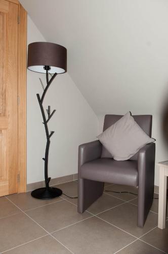 a lamp sitting next to a chair and a pillow at B&B Welcome Home in Laakdal